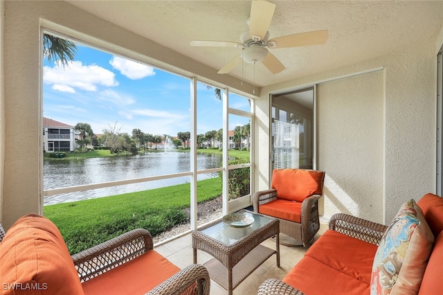 sunroom / solarium with ceiling fan and a water view