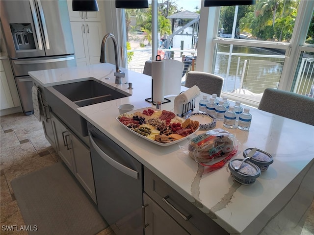 kitchen with light stone countertops, a wealth of natural light, and stainless steel appliances