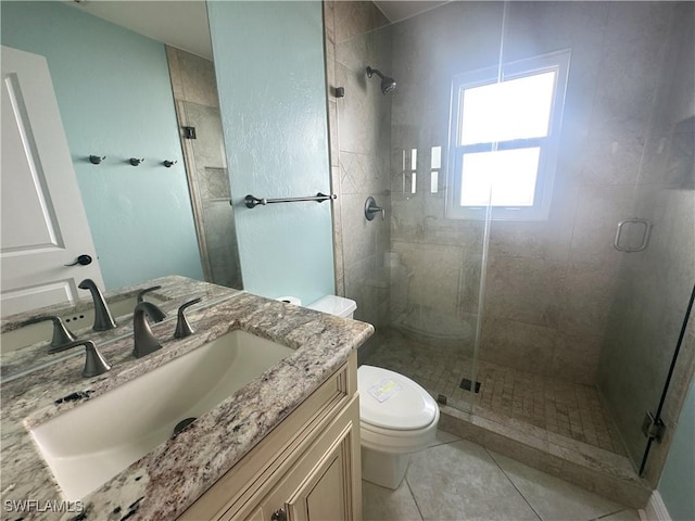 bathroom with vanity, tile patterned flooring, a shower with shower door, and toilet