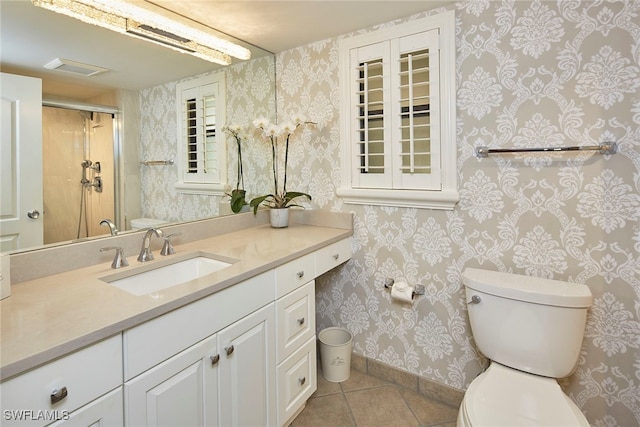 bathroom featuring walk in shower, vanity, toilet, and tile patterned flooring