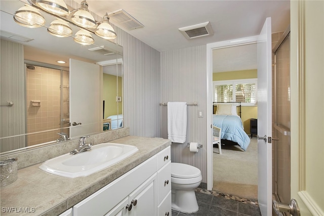 bathroom featuring toilet, vanity, tile patterned floors, and a shower with door