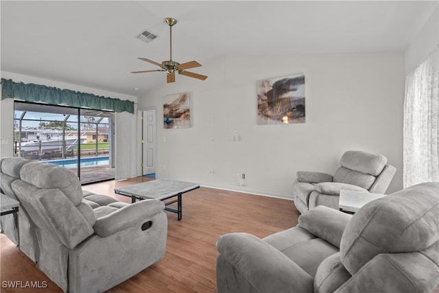 living room featuring light hardwood / wood-style flooring, vaulted ceiling, and ceiling fan