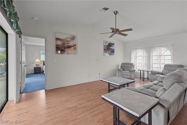 living room with ceiling fan, light hardwood / wood-style floors, and lofted ceiling