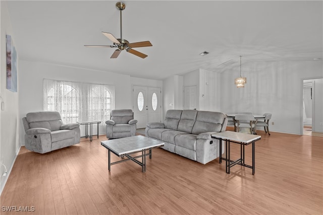 living room with ceiling fan, light wood-type flooring, and lofted ceiling