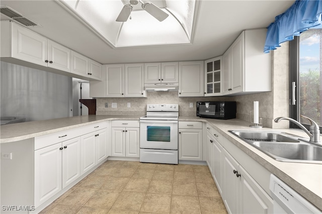 kitchen with ceiling fan, sink, kitchen peninsula, white appliances, and white cabinets