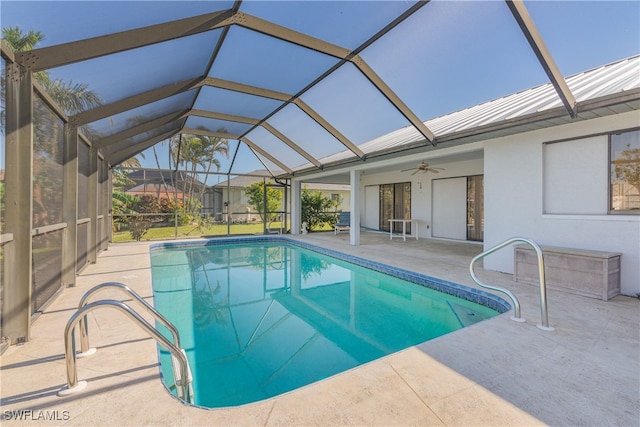 view of swimming pool featuring ceiling fan, a patio, and glass enclosure