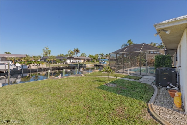 view of yard with a water view, a dock, central AC unit, and a lanai