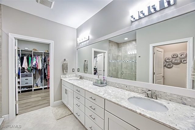 bathroom with walk in shower, vanity, and hardwood / wood-style flooring