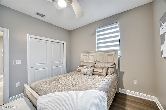 bedroom with dark hardwood / wood-style flooring, ceiling fan, and a closet