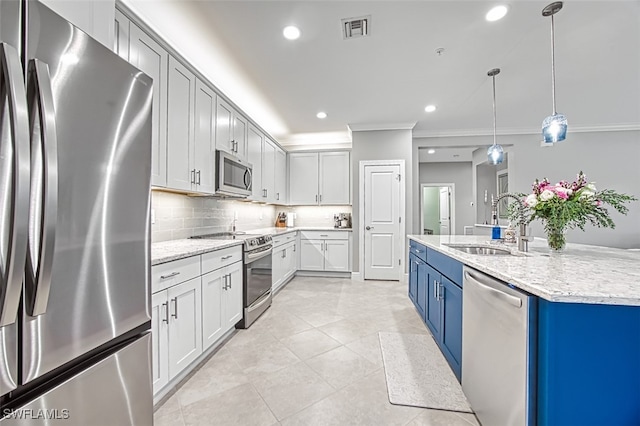 kitchen with sink, appliances with stainless steel finishes, light stone countertops, blue cabinets, and pendant lighting