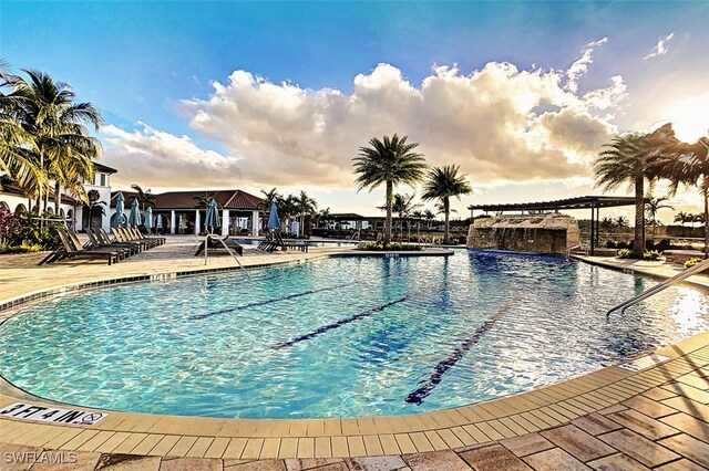 view of swimming pool with pool water feature and a patio area