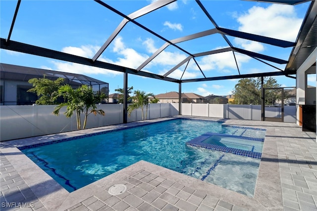 view of swimming pool with a lanai, a patio area, and an in ground hot tub