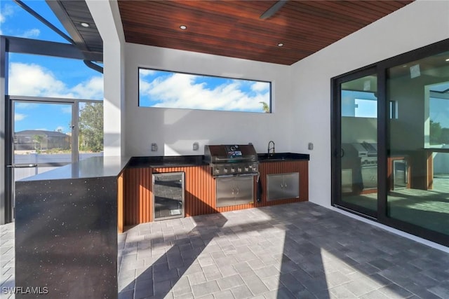 view of patio / terrace featuring an outdoor kitchen, sink, beverage cooler, and area for grilling