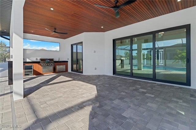 view of patio featuring area for grilling, sink, wine cooler, and ceiling fan