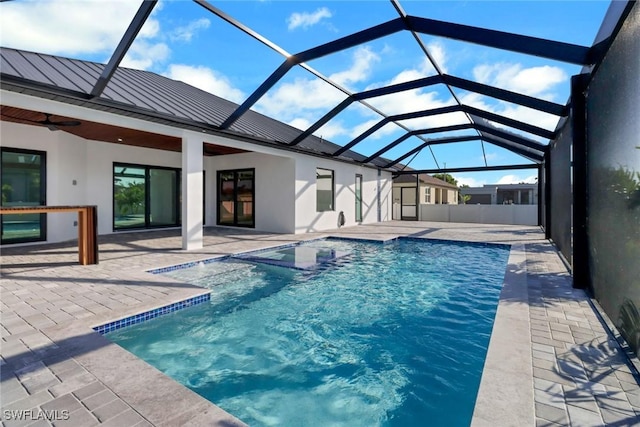 view of pool with a lanai, a patio, and ceiling fan