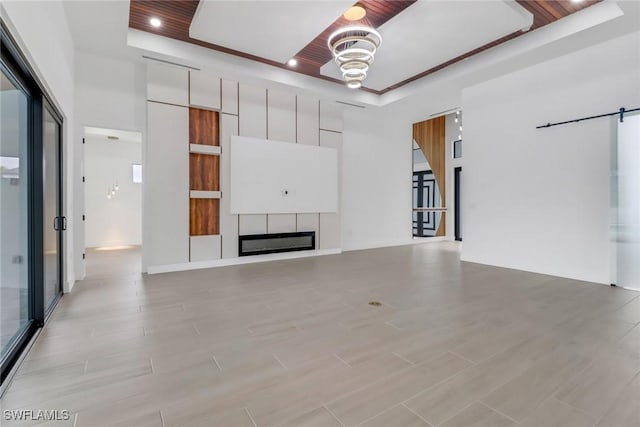 unfurnished living room featuring a raised ceiling and wood ceiling