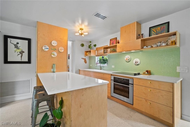 kitchen featuring open shelves, oven, a breakfast bar, black electric cooktop, and a sink