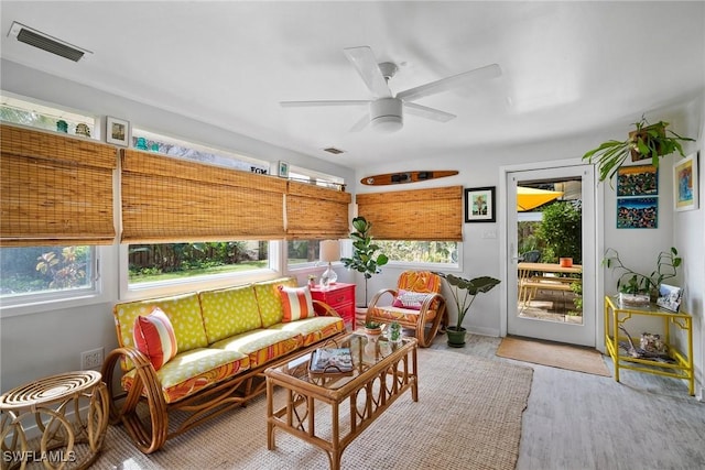 sunroom / solarium featuring a wealth of natural light, visible vents, and ceiling fan