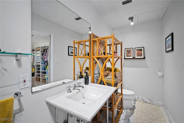 bathroom featuring visible vents, toilet, and a sink