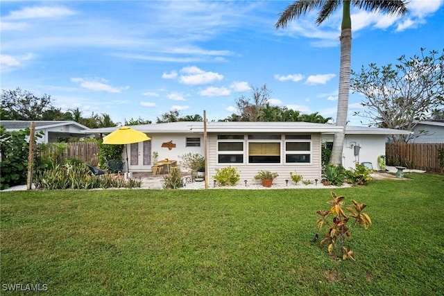 back of property with a patio area, a lawn, and fence