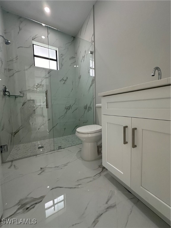 bathroom featuring toilet, vanity, and a shower with shower door