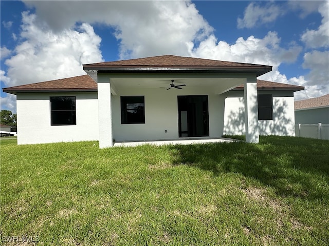 rear view of property featuring a patio, a lawn, and ceiling fan