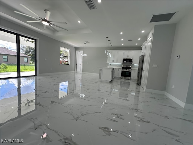 unfurnished living room with ceiling fan and sink