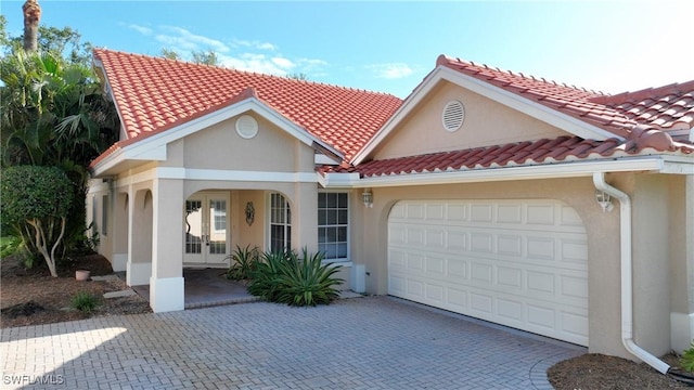 mediterranean / spanish-style house featuring a garage and french doors