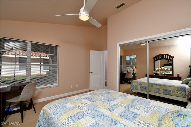 bedroom with a closet, vaulted ceiling, ceiling fan, and light colored carpet