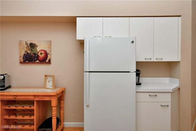 kitchen featuring white cabinetry and white fridge