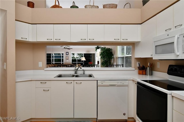 kitchen with ceiling fan, sink, a towering ceiling, white appliances, and white cabinets