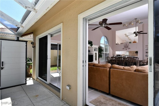 exterior space with light tile patterned floors, ceiling fan, and lofted ceiling