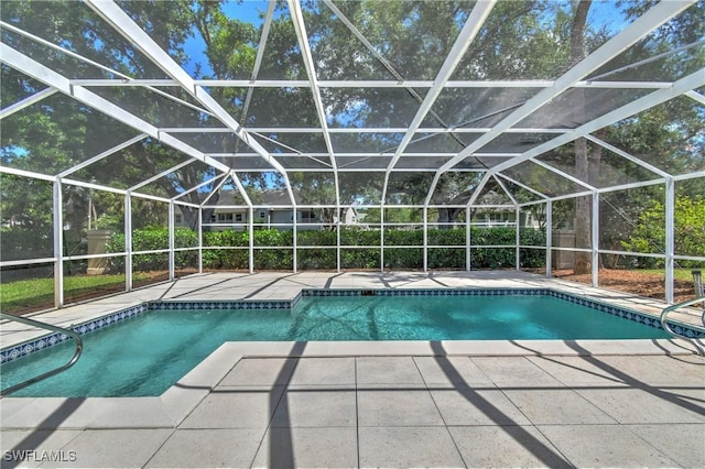 view of swimming pool with glass enclosure and a patio area