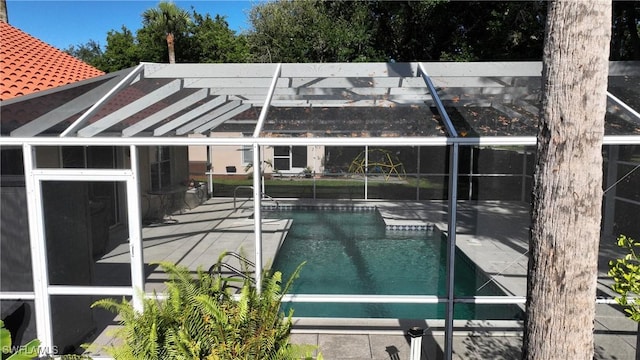 view of swimming pool featuring glass enclosure