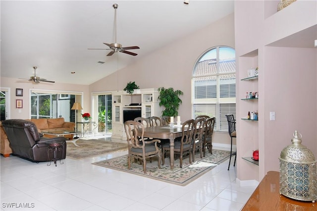 dining area with ceiling fan, light tile patterned floors, and vaulted ceiling