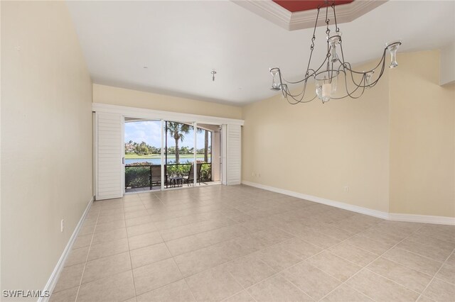 spare room with ornamental molding, light tile patterned floors, and a chandelier