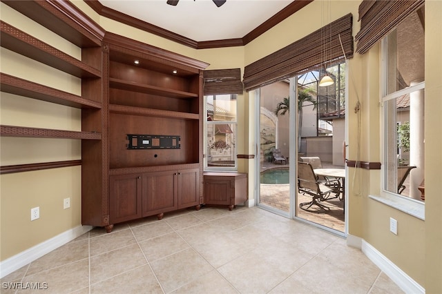 unfurnished office featuring ceiling fan, light tile patterned flooring, and crown molding