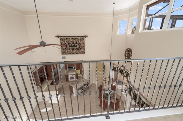 staircase with carpet flooring, ceiling fan, and ornamental molding