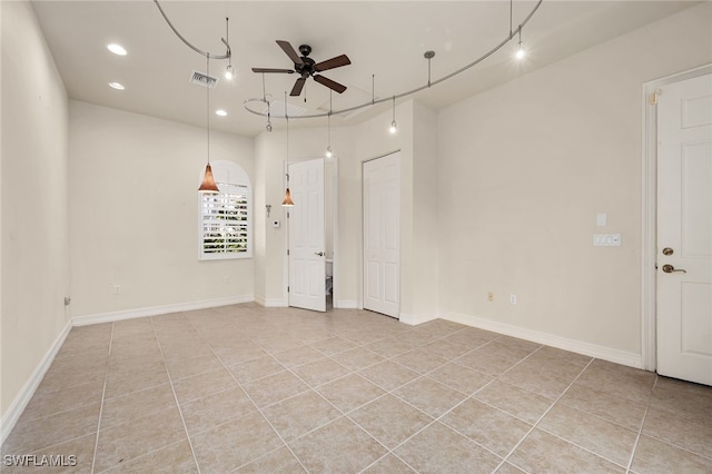 tiled spare room featuring ceiling fan