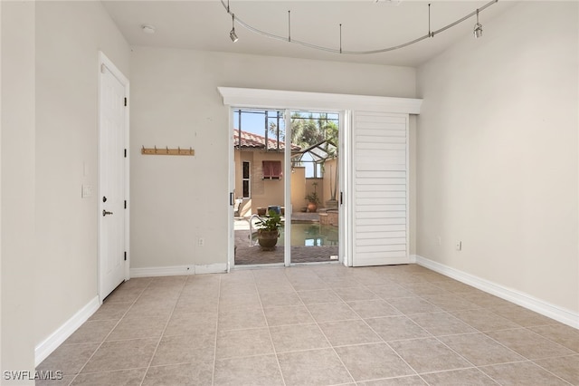 empty room featuring light tile patterned floors and baseboards