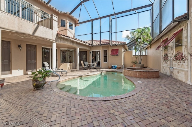 view of swimming pool with an in ground hot tub, a patio, and glass enclosure