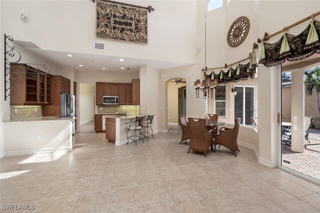 tiled dining area with a towering ceiling