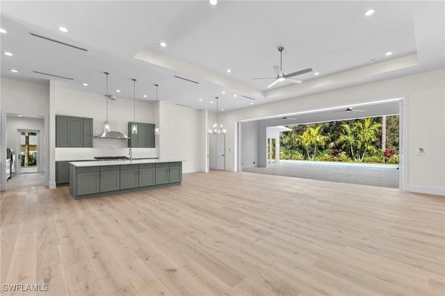 3509 5th Ave SW, Naples, FL 34117 - unfurnished living room featuring a raised ceiling, light wood-style floors, recessed lighting, ceiling fan, and baseboards