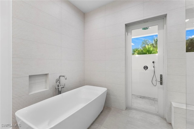 bathroom featuring tile walls, plenty of natural light, and shower with separate bathtub