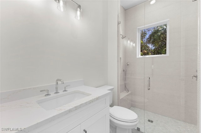 bathroom featuring a shower with shower door, vanity, and toilet