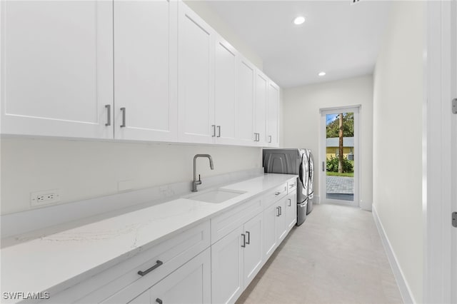 laundry area with cabinets, sink, and washer and dryer