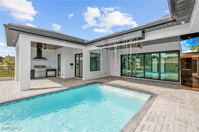 view of swimming pool featuring ceiling fan, a grill, exterior kitchen, and a patio