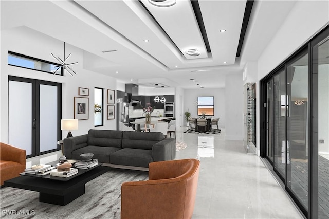 living room with a raised ceiling, french doors, and a healthy amount of sunlight