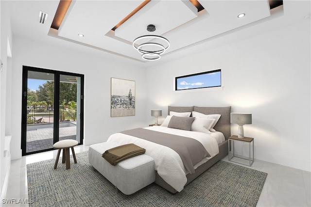 bedroom with access to outside and a tray ceiling