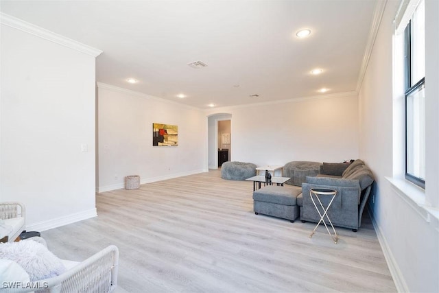 living area with light hardwood / wood-style floors and ornamental molding